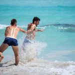 Gay-couple-playing-on-the-beach